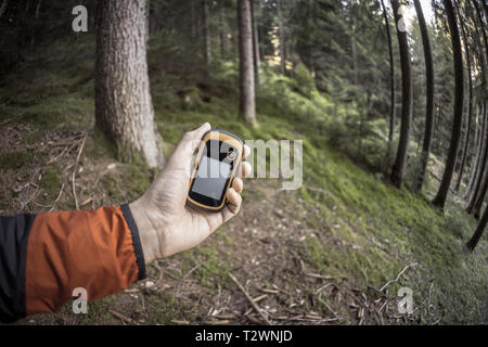 A l'aide du GPS Trekker parmi la forêt dans un jour nuageux Banque D'Images