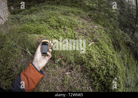 A l'aide du GPS Trekker parmi la forêt dans un jour nuageux Banque D'Images