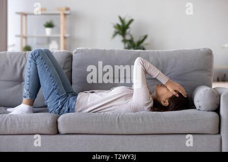 Longueur complète young woman lying on couch souffre de chagrin Banque D'Images