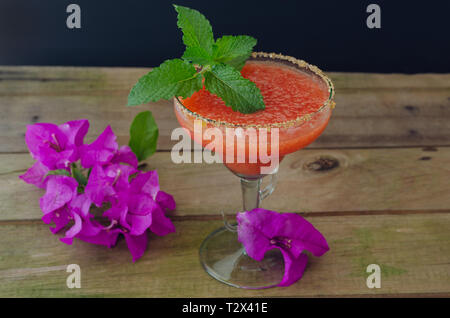 Strawberry margarita cocktail avec les feuilles de menthe sur fond de bois rustique. Banque D'Images