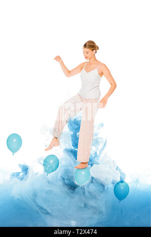 Jeune fille en pyjama bleu avec des ballons sur permanent illustration cloud Banque D'Images