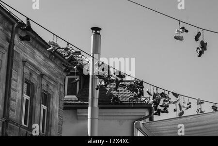 Photo en noir et blanc de chaussures suspendu à un fil à Ljubljana, Slovénie Banque D'Images