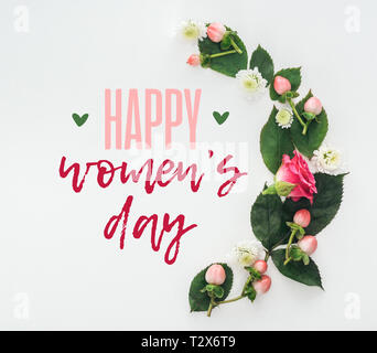 Vue de dessus de la composition avec des feuilles vertes, rose et de chrysanthèmes sur fond blanc avec happy womens day illustration Banque D'Images
