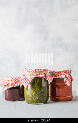 Divers types de conserves de sauce maison pour servir à la viande, tomates, oseille de adjika tkemali, à partir de la prune. Des préparations, devoirs et traditi Banque D'Images