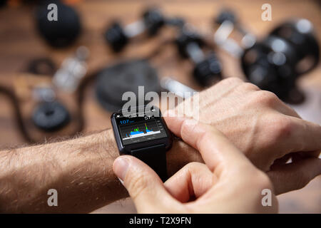 Portrait d'un athlète homme contrôler sa fréquence cardiaque à l'aide de Smart Watch Banque D'Images