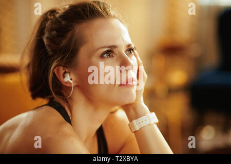 Portrait de femme pensive young sports fitness en vêtements dans la maison moderne. Banque D'Images
