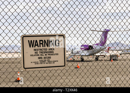 LAS VEGAS, NEVADA, USA - Février 2019 : panneau d'avertissement sur une clôture autour de l'aéroport international McCarran. Dans l'arrière-plan est un avion à réaction privé. Banque D'Images