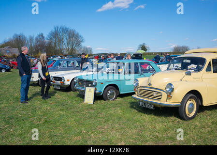 Newton, Cambridge, England, UK - Mars 2019 : classique vieille voiture vintage voir exposition tenue dans un champ ouvert piscine avec des personnes regardant les véhicules Banque D'Images