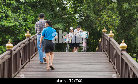 Bangkok, Thaïlande - 25 septembre 2018 : les filles Thai avec des vélos de marche sur un pont de bois vers d'autres passants dans un parc en Bang Krachao. Banque D'Images