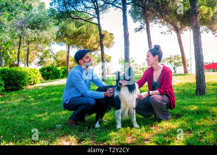 Jeune couple avec un chien dans un parc de la ville Banque D'Images