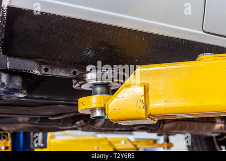 Bras de levage voiture tenant un véhicule dans un gros plan extrême de l'atelier Banque D'Images