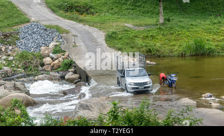 La conduite de camions à travers rivière garçon moto lavage Banque D'Images