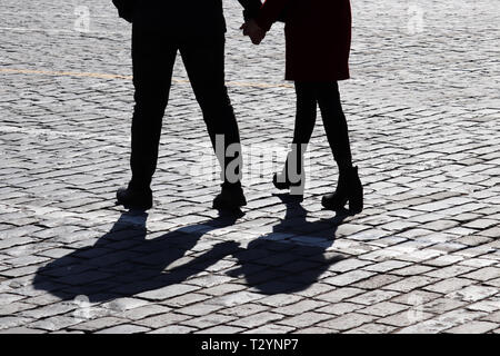 Silhouette de l'amour couple dans la rue. Deux personnes à pied et se tenir la main, ombres sur la chaussée, concept pour l'amour romantique, famille, relations Banque D'Images