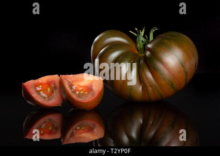 Groupe d'un ensemble de deux tranches de tomate fraîche primora isolé sur verre noir Banque D'Images