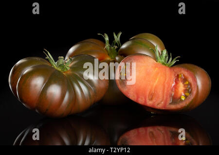 Groupe de deux ensemble la moitié de la tomate fraîche primora isolé sur verre noir Banque D'Images