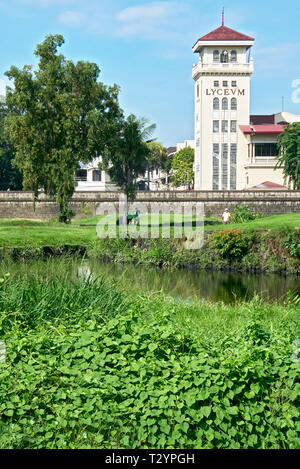 Manille, Philippines : green de golf en face du mur intramuros et les bâtiments de l'Université des Philippines Lyceum Banque D'Images