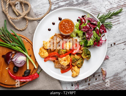 Affiche pour les restaurants. Ragoût d'Myasne avec tomates, brocoli et de la salade. Sur un fond clair. Flay lay. Vue d'en haut Banque D'Images