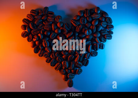 Les grains de café sont mis en évidence par des néons colorés bordée en forme de cœur Banque D'Images