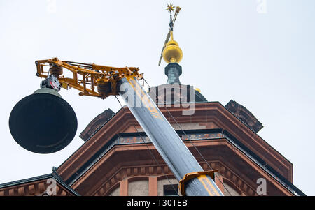 Leipzig, Allemagne. Le 05 Avr, 2019. Une grue soulève la plus grande cloche pesant 2342 kg de la tour de la Nikolaikirche de Leipzig. Un total de trois cloches ont été enlevées et levé de la tour dans un camion. Deux cloches sont portées à une fonderie à Neunkirchen pour vérifier l'harmonie avec cinq nouvelles cloches. Le jour de la révolution pacifique, le 09 octobre 2019, les huit cloches sonneront pour la première fois. Credit : Hendrik Schmidt/dpa-Zentralbild/ZB/dpa/Alamy Live News Banque D'Images