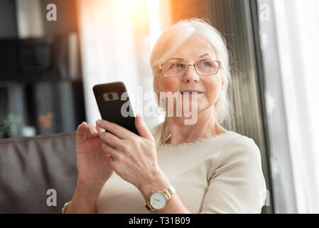 Portrait of senior woman with élégant téléphone intelligent. Photo de Mode femme de pension. Banque D'Images