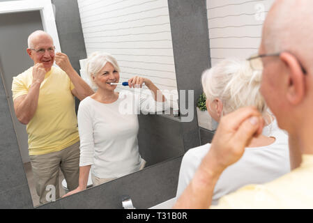 Les personnes âgées avec le brossage des dents et la soie dentaire. Matin dans la salle de bains Banque D'Images