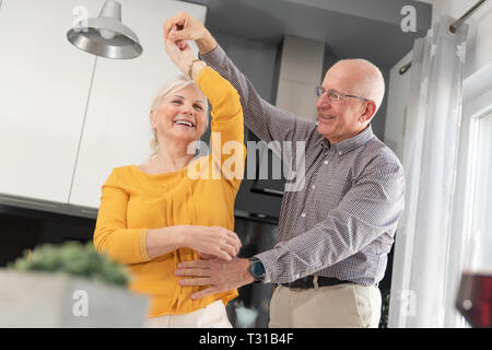 Senior couple dancing and smiling at home. Heureux couple de retraités Banque D'Images