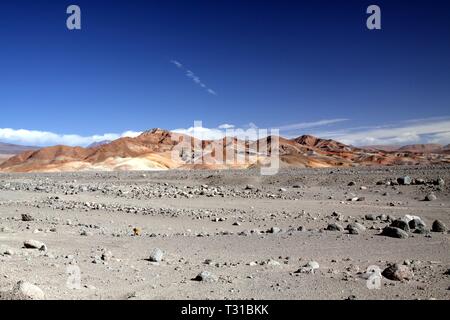 Vue sur des terres incultes et stériles pierreux sur les collines rouges colorés contrastant avec ciel bleu profond dans le nulle part du désert d'Atacama, Chili Banque D'Images