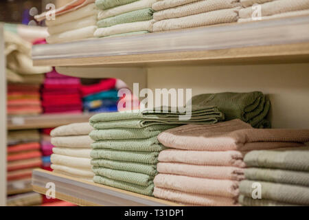 Pile de serviettes colorées dans le grand magasin. De nombreux tas de serviettes en coton dans le magasin de souvenirs. Concept de shopping, acheter et vendre. Banque D'Images