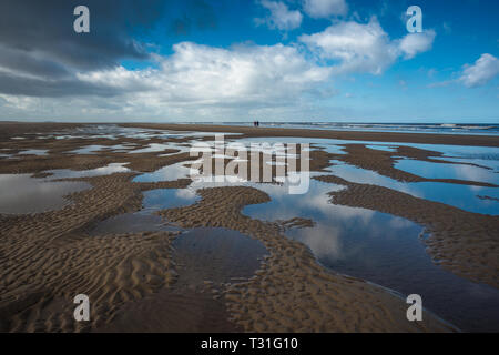 Motifs faits par des bassins de marées d'eau à marée basse sur la plage de Burnham Overy Staithe sur la baie de Holkham, la côte nord de Norfolk, East Anglia, Angleterre, Royaume-Uni. Banque D'Images