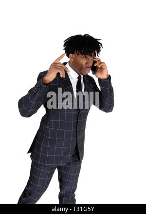 Un beau black homme en complet et permanent à parler sur son téléphone cellulaire des gestes avec sa main, isolée pour fond blanc Banque D'Images