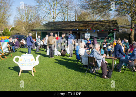 Newton, Cambridge, England, UK - Mars 2019 : les personnes bénéficiant d'un plateau à l'extérieur en plein air dans le jardin d'un café de thé anglais Banque D'Images