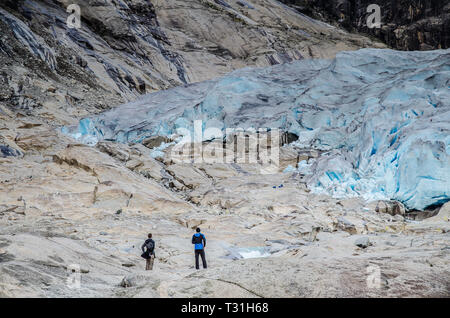 Fermer la vue de Jostedal glacier Nigardsbreen avec deux touristes en regardant le glacier. Banque D'Images