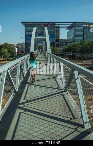 Petite fille sur fer passerelle pour piétons au-dessus de l'autoroute à fort trafic à Madrid. Capitale de l'Espagne avec dynamisme et vie culturelle intense. Banque D'Images