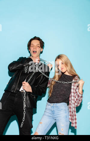 Mauvais jeux. Close up fashion portrait de deux jeunes cool hipster girl and boy portant des jeans usés. Studio shot of two cheerful meilleurs amis s'amusant et en faisant des visages. ludique Banque D'Images