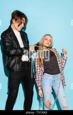 Mauvais jeux. Close up fashion portrait de deux jeunes cool hipster girl and boy portant des jeans usés. Studio shot of two cheerful meilleurs amis s'amusant et en faisant des visages. ludique Banque D'Images