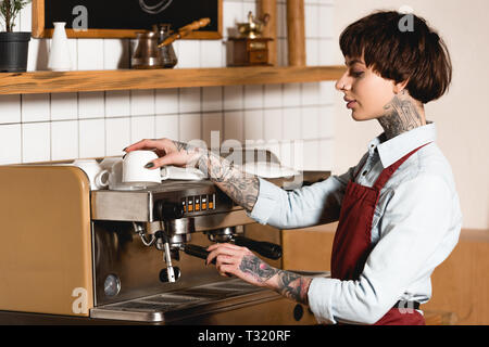 Joli café barista tatoué sur machine à café Banque D'Images