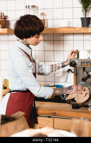 Focus sélectif de jolie nettoyage barista machine à expresso, chiffon en coffee shop Banque D'Images