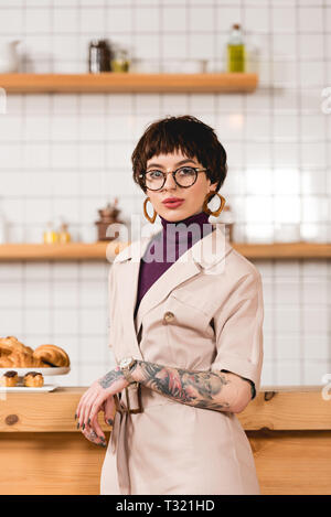 Trendy, attractive businesswoman standing près de comptoir de cafétéria Banque D'Images