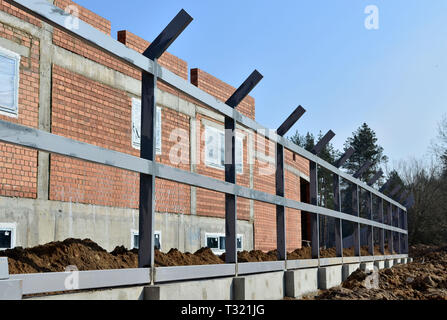 La construction de clôtures . La maçonnerie du chantier, des colonnes avec des profilés métalliques pour la nouvelle clôture Banque D'Images