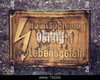 Image d'un vieux yeloow panneau d'avertissement avec flash et mots allemand Hochspannung Vorsicht Lebensgefahr, ce qui signifie danger haute tension Banque D'Images