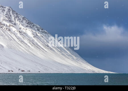 La neige qui tombe sur un paysage spectaculaire de montagnes et fjord près de Ísafjörður dans la région de l'Islande Westfjords Banque D'Images