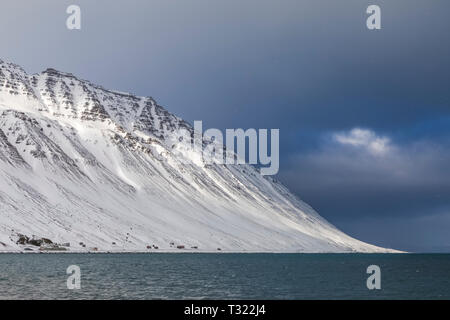 La neige qui tombe sur un paysage spectaculaire de montagnes et fjord près de Ísafjörður dans la région de l'Islande Westfjords Banque D'Images