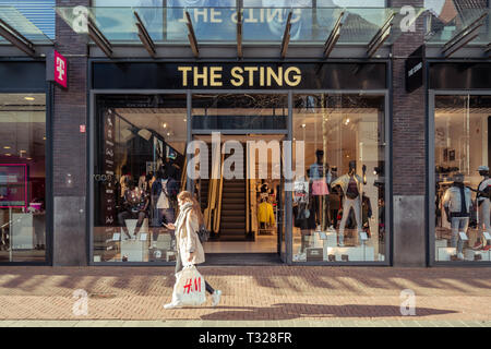 Dordrecht, Pays-Bas - Mars 03, 2019 : Girl walking passé Sting Megastore est le foyer de diverses marques avec un accent sur les jeunes. Sting est Entreprises Banque D'Images