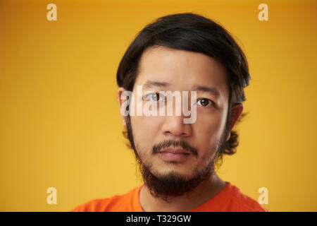 Asian guy headshot isolé sur fond de couleur jaune. Thème Poker face Banque D'Images