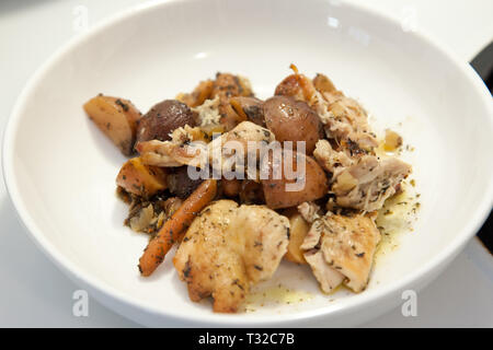 Bol blanc avec du ragoût de poulet avec des pommes de terre et de carotte Banque D'Images