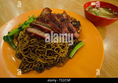 Vue rapprochée de l'wantan mee servi avec de la sauce soja,du rôti de porc et de légumes. C'est un mandarin cuisine chinoise. Banque D'Images