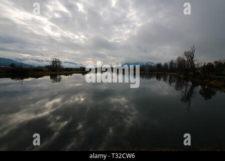 Un arrière-plan placide de la rivière Vedder reflète un ciel gris turbulent couvert à Chilliwack, en Colombie-Britannique, au Canada Banque D'Images