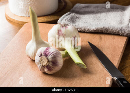 L'ail frais jeunes et le couteau sur la table de la cuisine. Banque D'Images