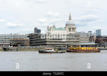 Récupération une barge en activité sur la Tamise passe devant la cathédrale Saint-Paul sur la Tamise, Londres, Royaume-Uni Banque D'Images