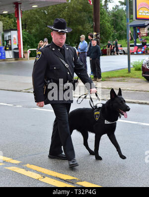 Un agent de police en marchant le 4 juillet parade avec son K-9 police dog en spéculateur, NY USA Banque D'Images